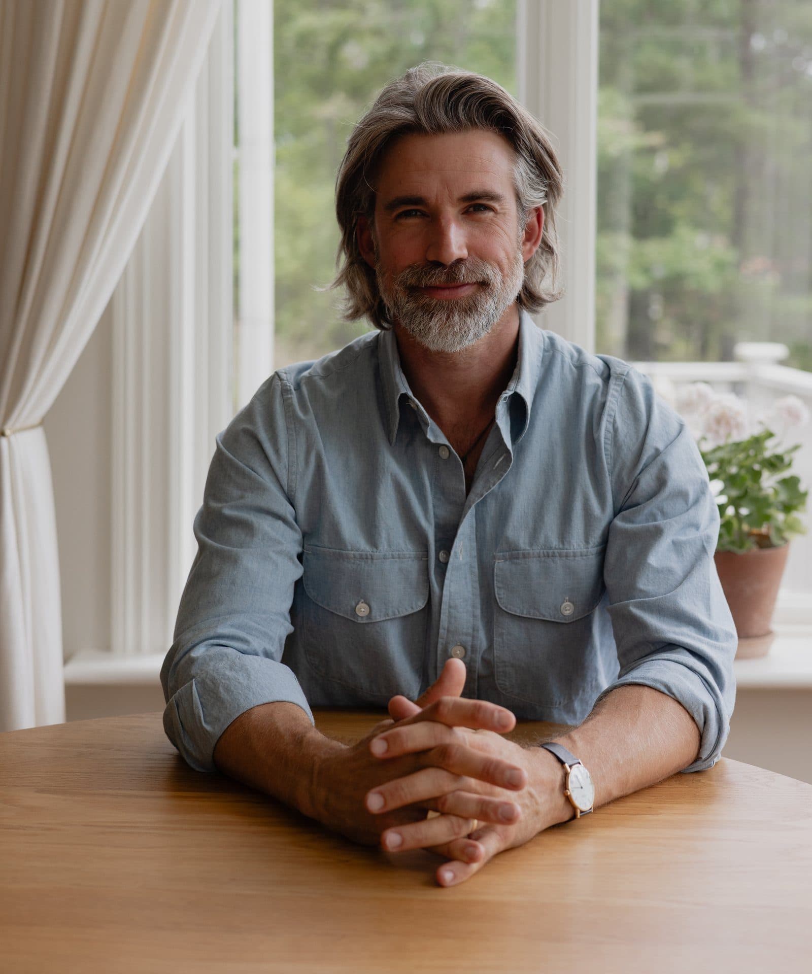 Oliver Adan at a table by a window.