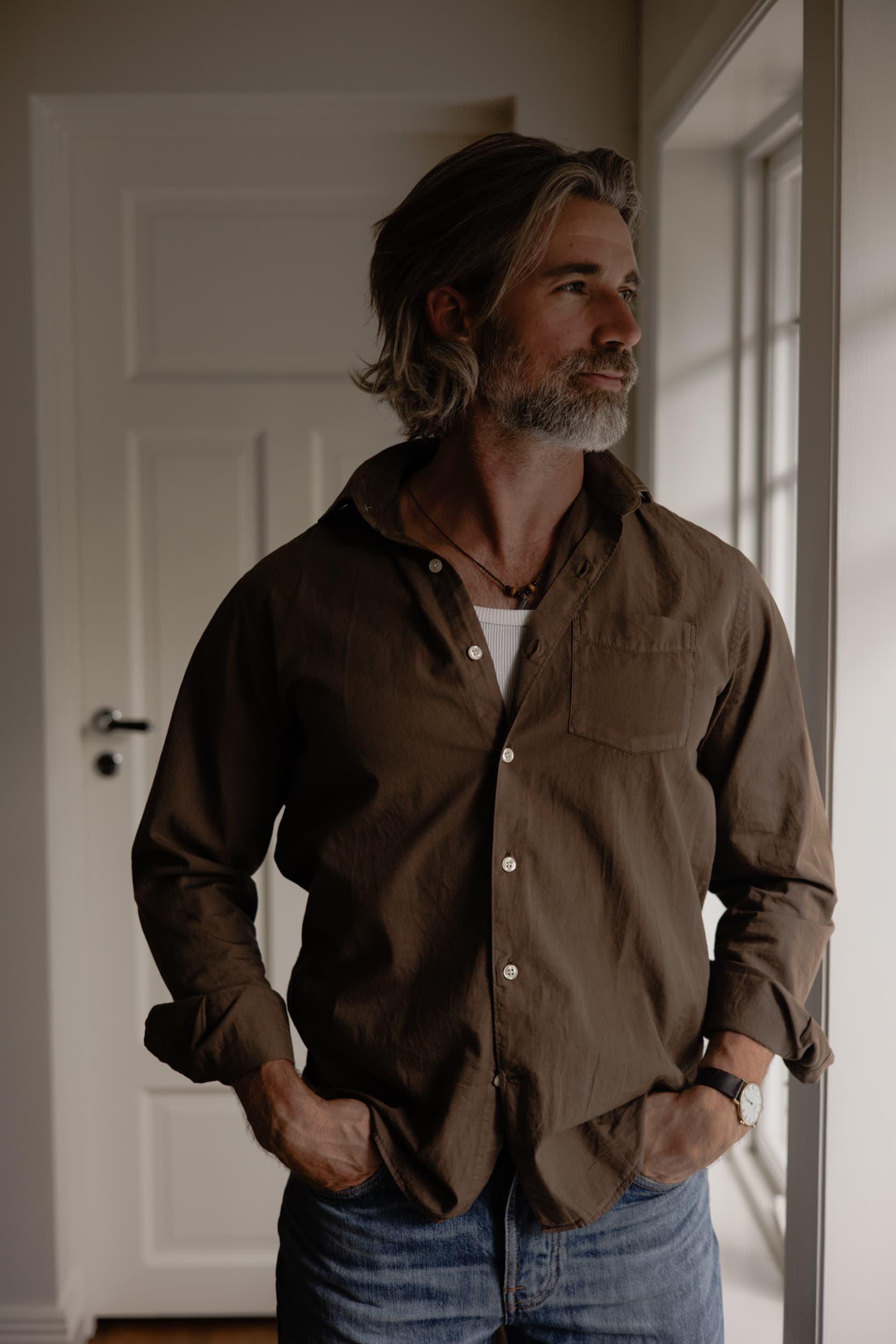 Oliver Adan standing by a window at home.